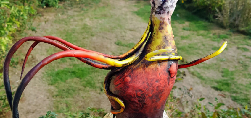 Hästskulptur med böljande man och svans som skiftar från svart över rött och gult